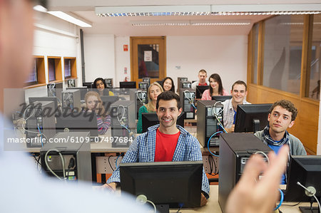 Cheerful students listening to lecturer in their computer class at the university