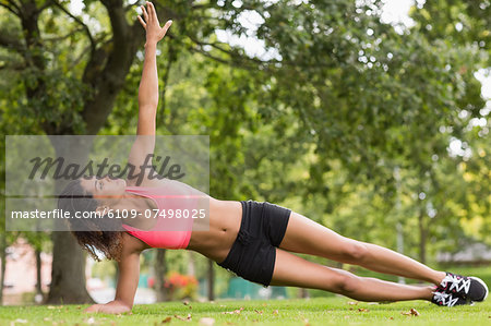 Full length of a toned young woman doing stretching exercise in the park