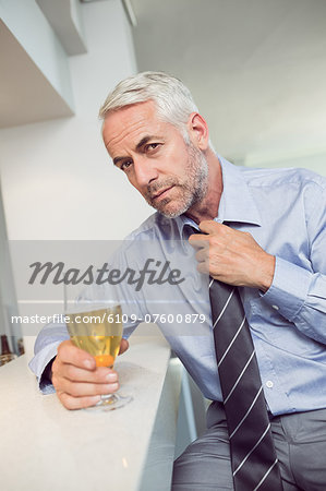 Tensed mature businessman with beer glass at bar counter