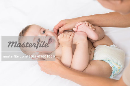 Baby boy receiving massage from mother