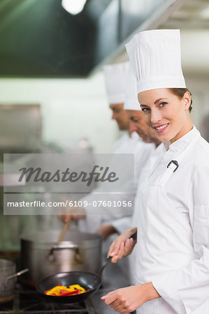 Happy chef smiling at camera while cooking at stove