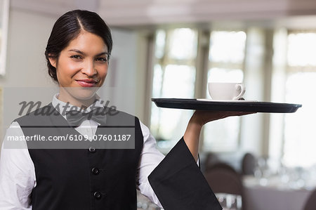 Pretty waitress holding a tray with a cup