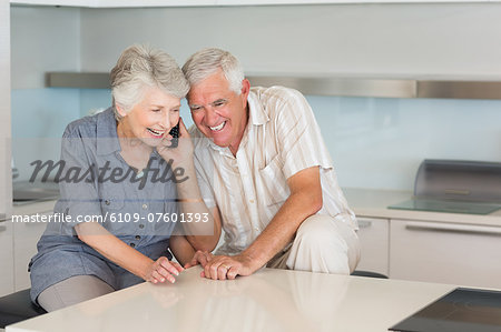 Happy senior couple listening to the phone