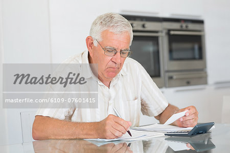 Focused senior man paying his bills