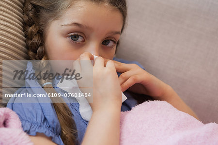 Close-up of a girl blowing nose with tissue paper