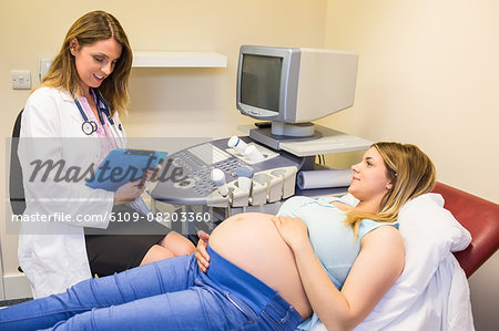 Doctor talking to pregnant smiling patient
