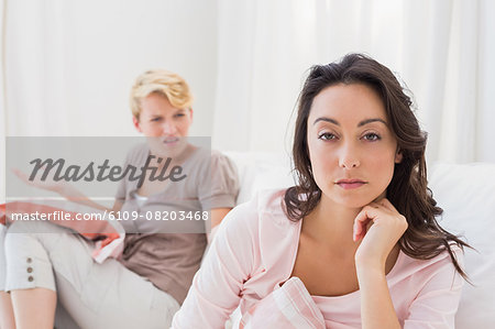 Homosexual couple sitting on couch and disputing