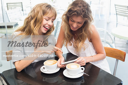 Beautiful women sitting and looking at mobile phone