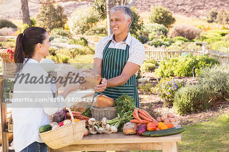 Smiling brunette customer buying vegetables