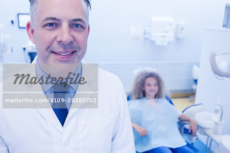 Pediatric dentist and little girl smiling at the camera