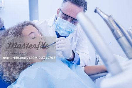 Pediatric dentist examining his young patient