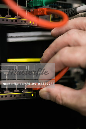 Technician inserting wire to server Technician inserting wire to server