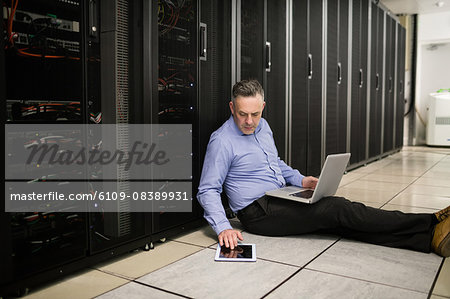 Technician using laptop to analyse server