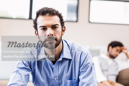 Troubled man sitting in foreground