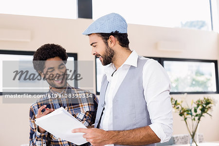 Happy gay couple holding document