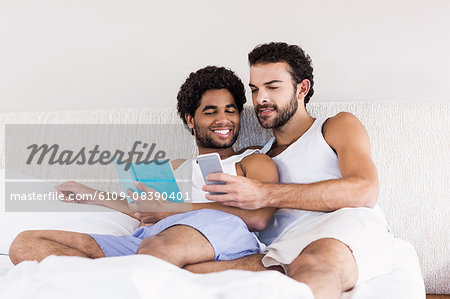 Happy gay couple on bed together