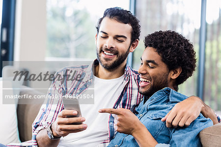 Happy gay couple using smartphone
