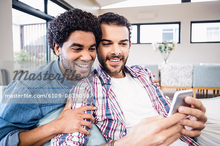 Happy gay couple using smartphone