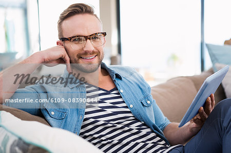 Casual man using tablet on sofa