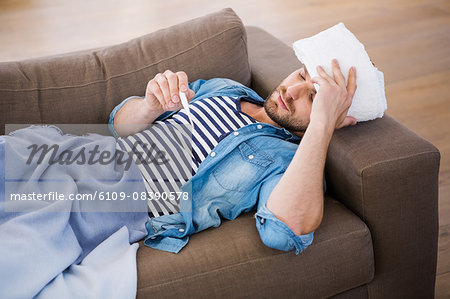 Sick man checking his temperature Sick man checking his temperature