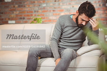Stressed man holding his forehead