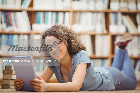 Pretty student in library using tablet Pretty student in library using tablet