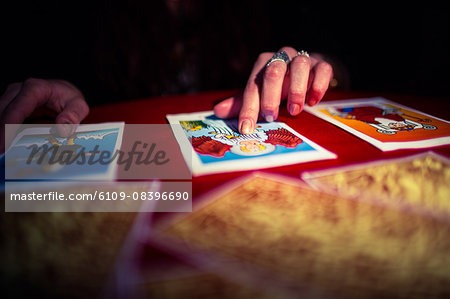 Close-up of fortune teller pointing at tarot cards