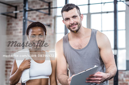 Woman discussing her performance on clipboard with a trainer