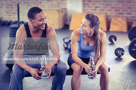 Fit couple drinking water together