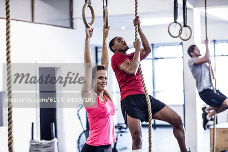 Athletes doing ring gymnastics and climbing rope