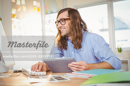 Happy creative businessman with digital tablet looking in computer