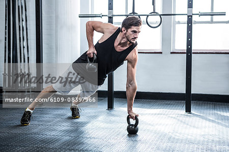 Fit man working out with kettlebells