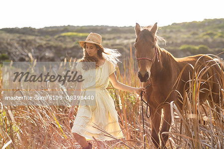 Young happy woman walking with her horse