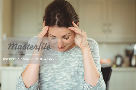 Woman with a headache at home