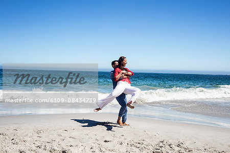 Boyfriend Carrying Girlfriend And Having Fun On The Beach Stock Photo Masterfile Premium Royalty Free Code 6109 08434739