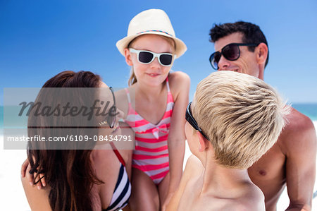 Cute family wearing sunglasses on the beach