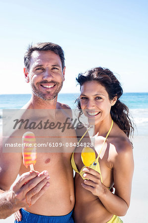 Cute couple eating ice creams on the beach