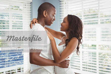 Ethnic couple looking at each other in the living room