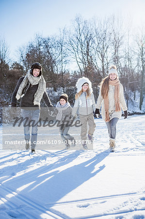 Happy family holding hands on a beautiful snowy day