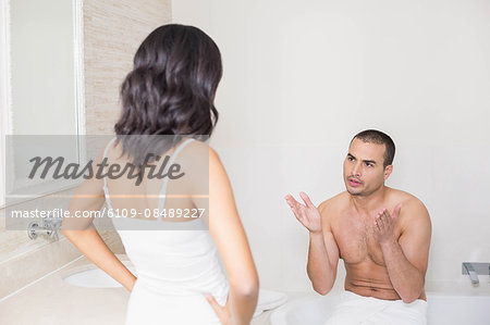 Unhappy young couple arguing in bathroom