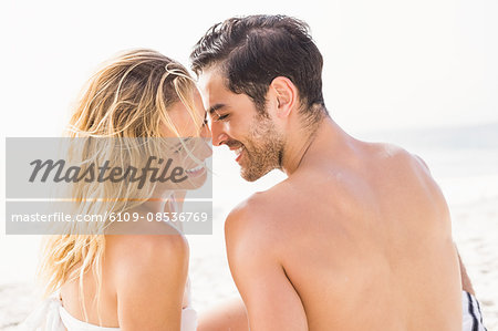 Happy couple sitting on the beach