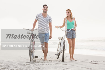 Cute couple walking next to their bicycles
