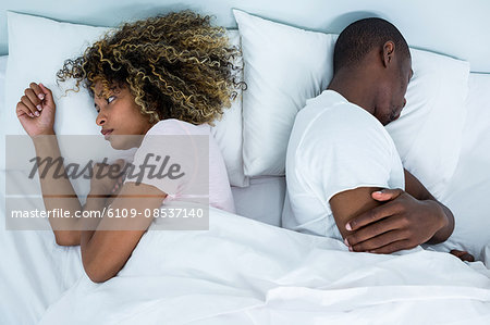 https://image1.masterfile.com/getImage/6109-08537140em-young-couple-sleeping-back-to-back-and-ignoring-each-other-stock.jpg