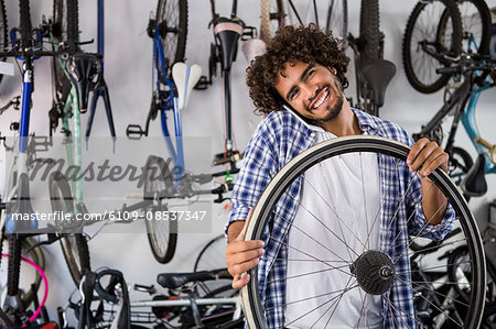 Worker using phone while repairing bikes