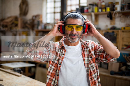 Portrait of carpenter holding ear muff