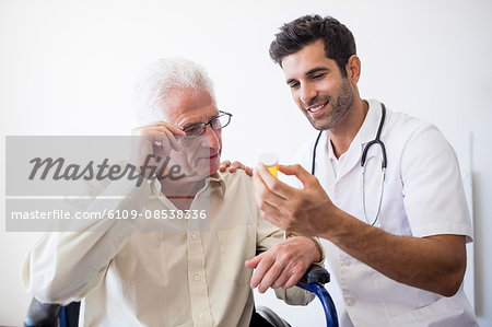 Nurse giving pills to senior man