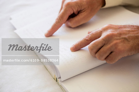 Blind senior woman using braille to read