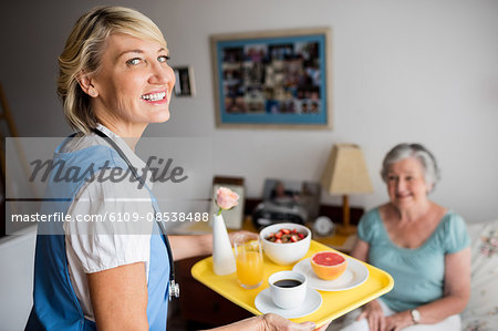 Nurse giving food to a senior woman