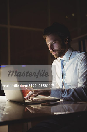 Businessman using laptop at night