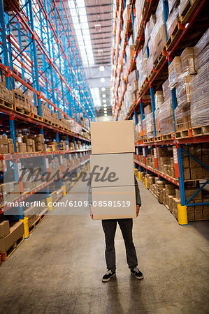 Obscured worker carrying boxes